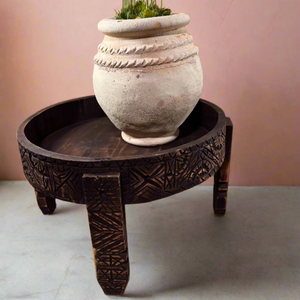 Small Moroccan terracotta planter with greenery on a wooden table