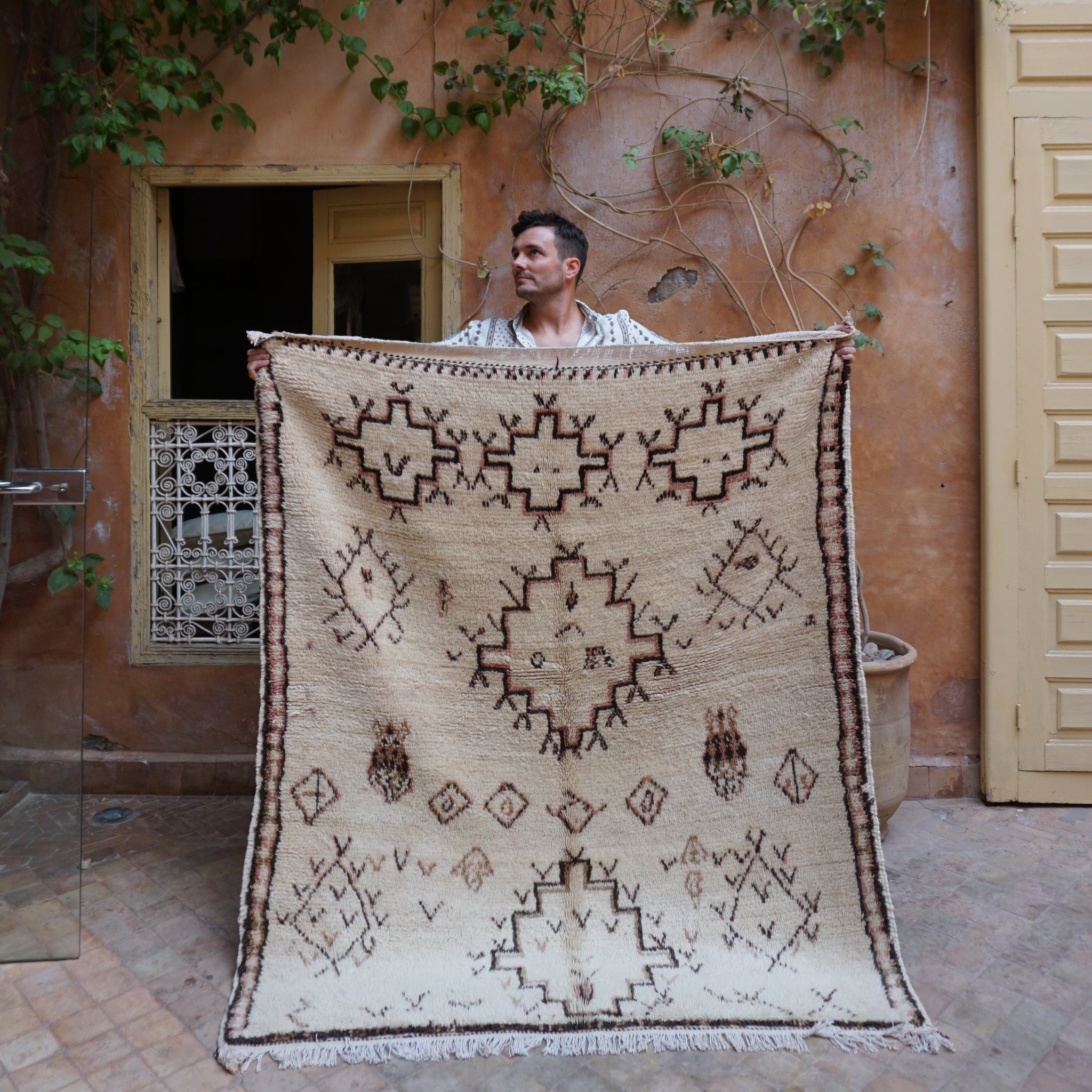 person holding vintage rug in Marrakech Riad